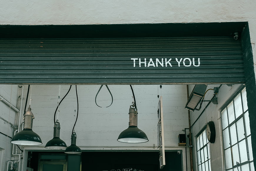 Industrial interior with hanging lamps and thank you sign