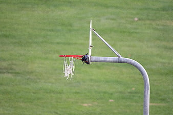 Outdoor basketball hoop with net on green grass field