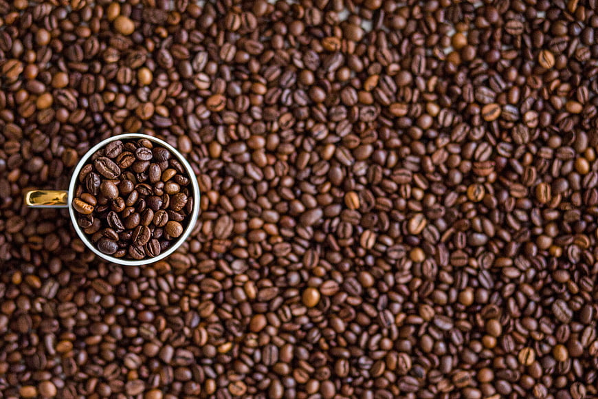 Top View of Coffee Beans in White Cup on Background