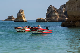 Traditional Fishing Boats Near Coastal Rock Formations