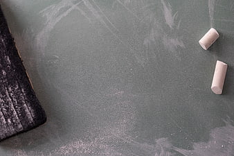 Green chalkboard with chalk and eraser flat lay background