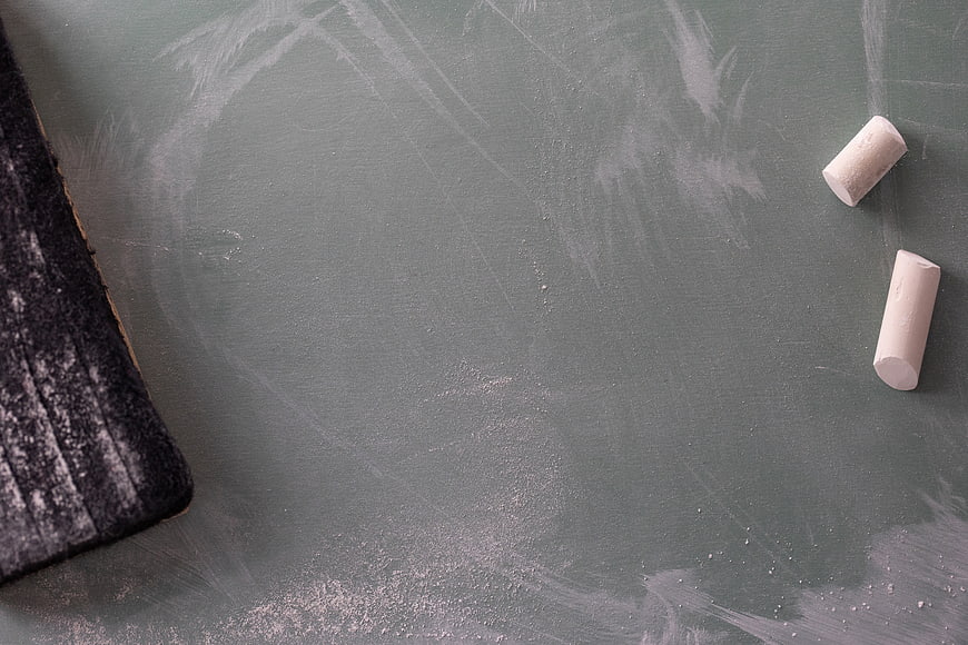 Green chalkboard with chalk and eraser flat lay background