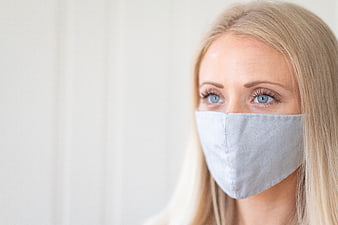Close-up portrait of blonde woman wearing grey face mask