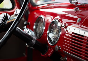 Close-up of vintage red Chevy dashboard with chrome gauges