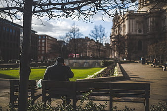 Man sitting alone on park bench in London