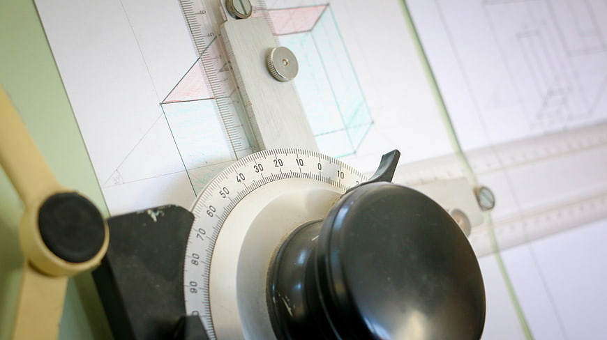 Close-up of vintage drafting machine on architectural blueprint