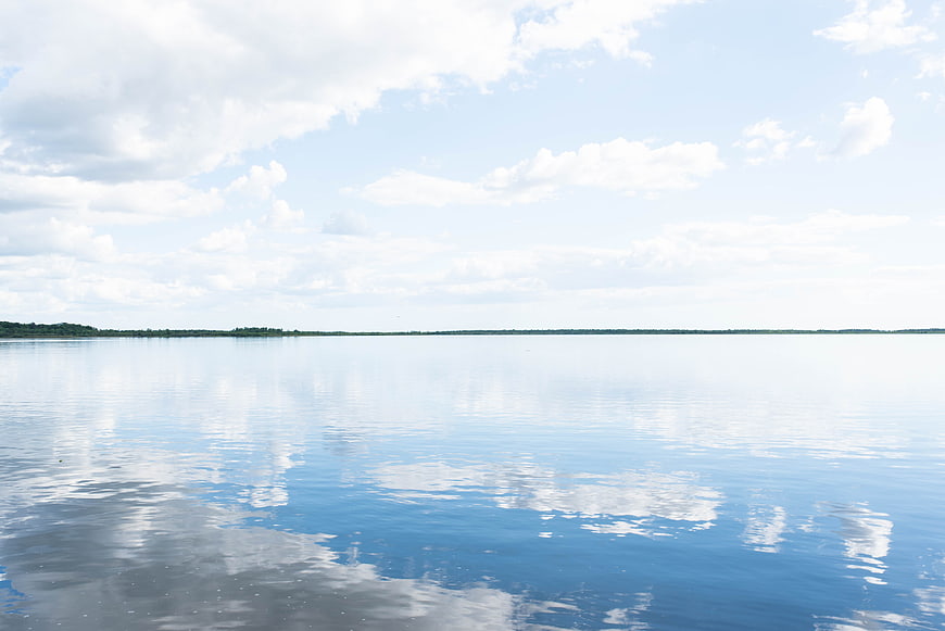 Serene Lake Landscape with Cloud Reflections and Blue Sky