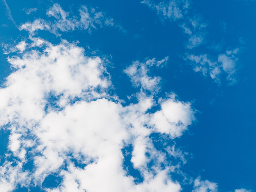Fluffy white clouds against a vibrant blue sky background