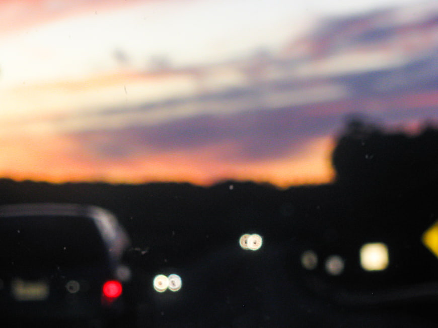 Blurry sunset view from car on highway at dusk