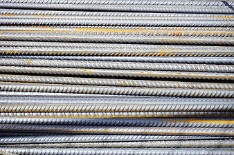 Stack of gray steel rebar rods with rust texture