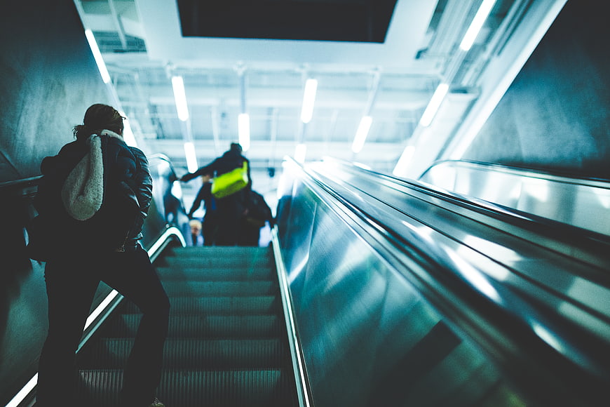 People Riding Escalator in Modern Urban Transit Station