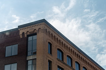 Low angle view of historic brick building corner against blue sky