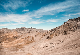 Arid mountain landscape with blue sky and wispy clouds