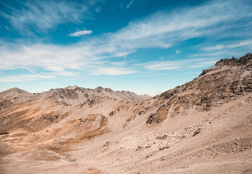 Arid mountain landscape with blue sky and wispy clouds