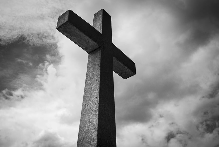Low Angle Black and White Concrete Cross Against Cloudy Sky