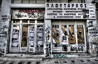 Abandoned Greek Shop Front with Graffiti and Boarded Windows