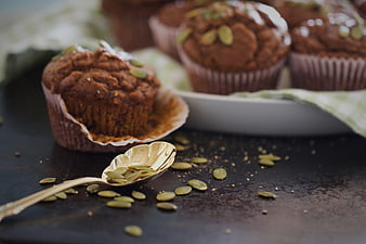 Homemade pumpkin muffins with seeds on dark rustic table