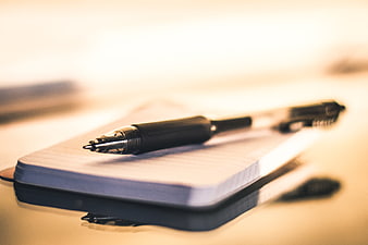 Black pen on notepad with shallow depth of field
