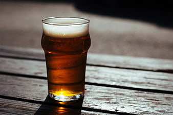 Glass of Amber Beer on Weathered Wooden Table