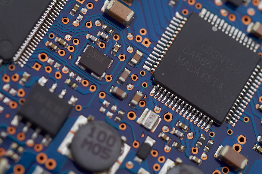 Macro shot of blue circuit board with microchips and electronic components