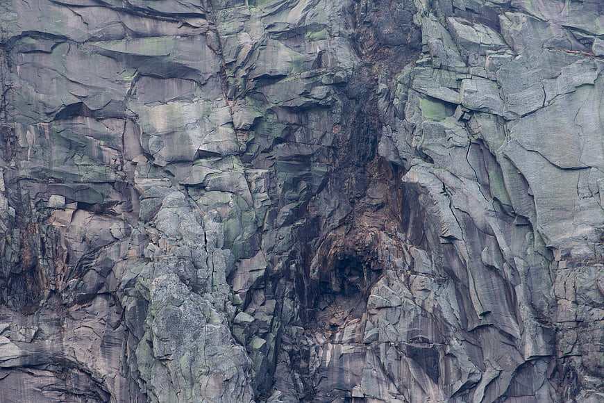 Close-up texture of rugged gray rock cliff face