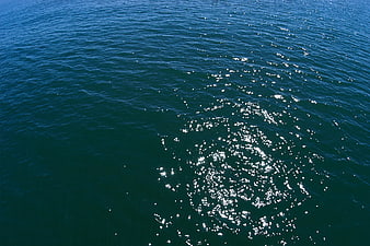 Sparkling Sunlight on Deep Blue Ocean Water Surface