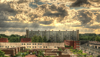 Dramatic HDR cityscape with sunbeams over urban buildings