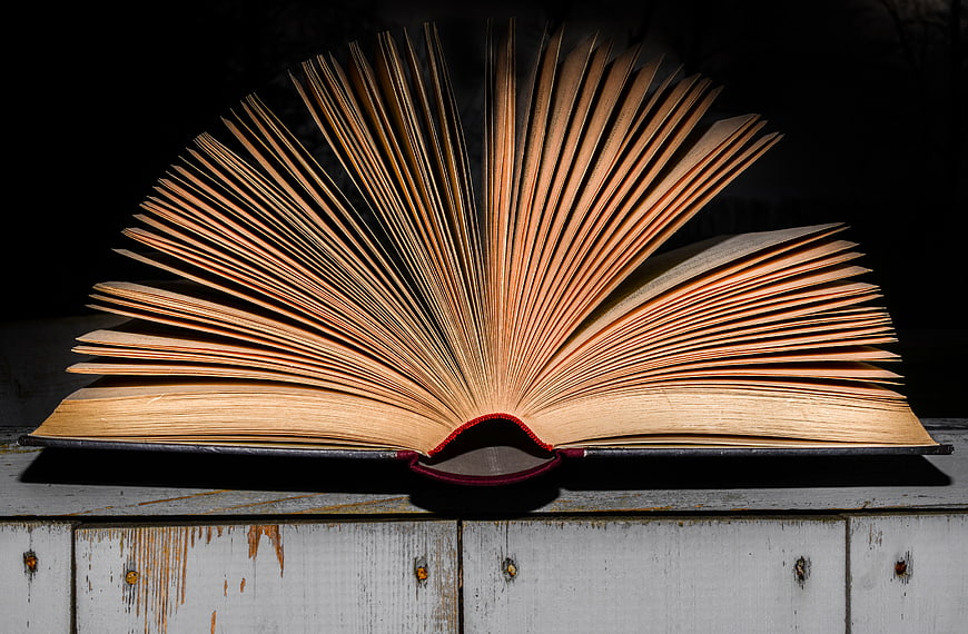 Open Vintage Book with Fanned Pages on Wooden Surface