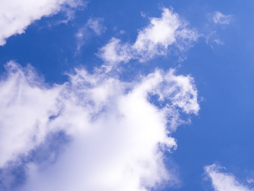 Fluffy white clouds against a vibrant blue sky background