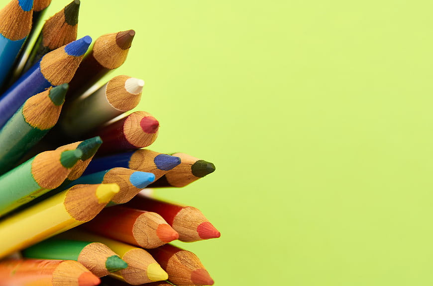 Close-up of colorful wooden pencils on lime green background