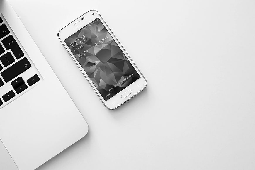 White Smartphone and Laptop on Clean Desk Surface