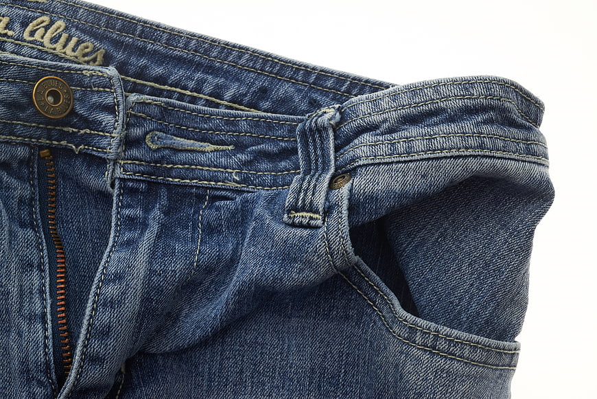 Close-up of blue denim jeans waistband and pocket detail
