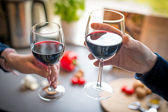Two Hands Toasting with Red Wine Glasses