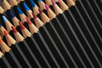 Close-up of colorful pencils arranged diagonally on black background