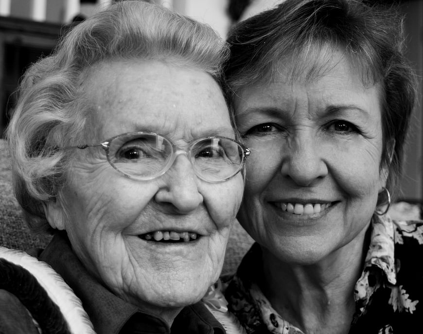 Black and white portrait of elderly grandmother and daughter smiling