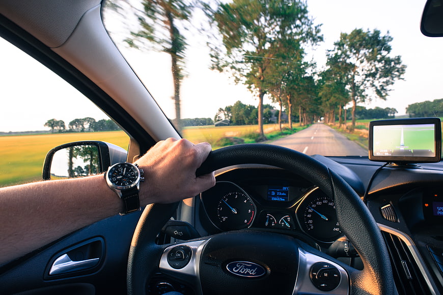 Man driving car on country road with GPS navigation