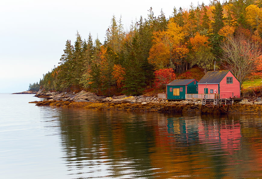 Colorful Boathouses on Rocky Coastline in Autumn