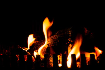 Close-up of burning wood logs in a dark fireplace