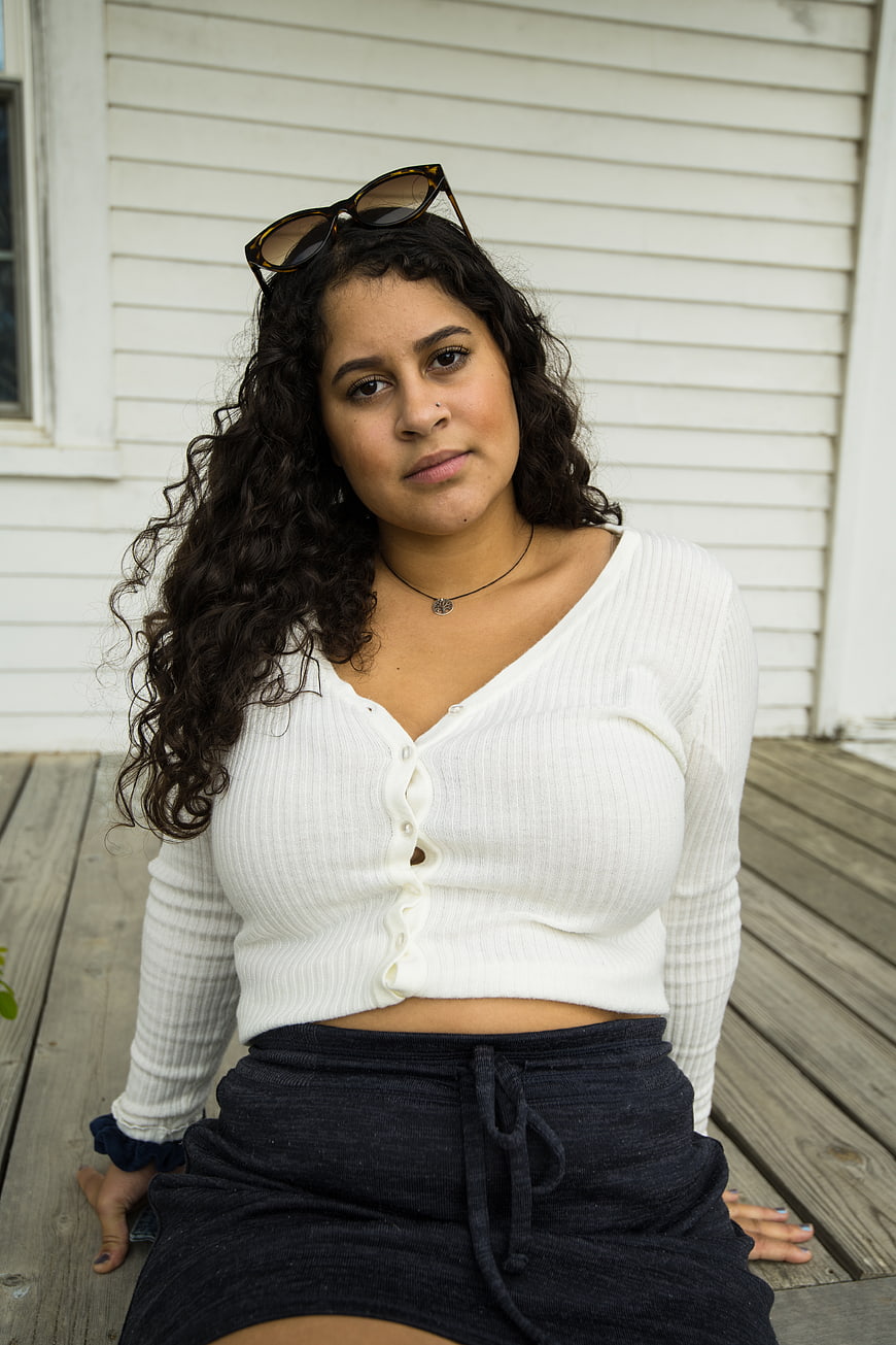 Portrait of young woman with curly hair on wooden deck