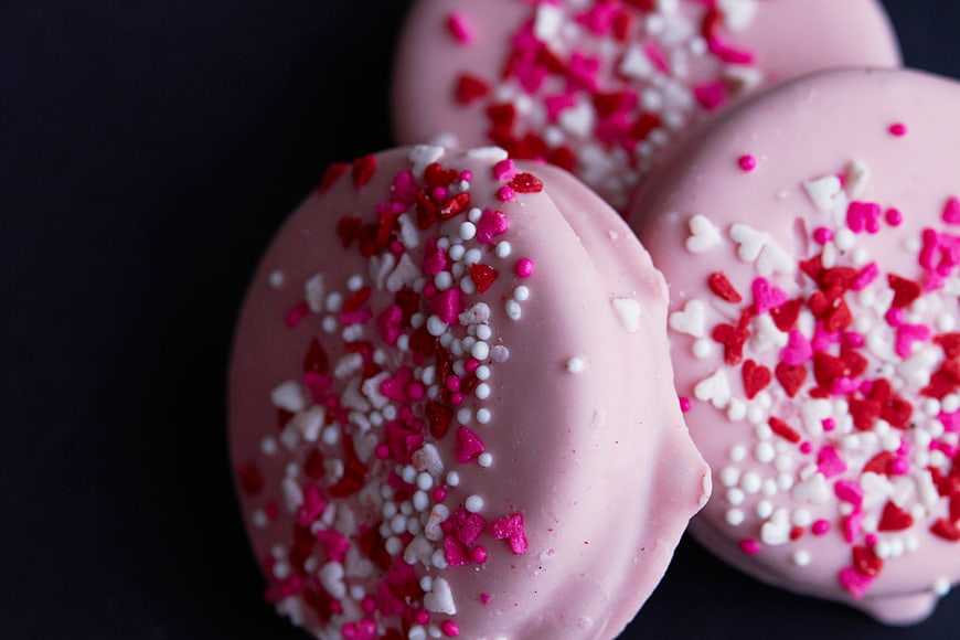Pink Chocolate Cookies with Heart Sprinkles on Black Background