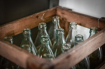 Vintage green glass bottles in a rustic wooden crate