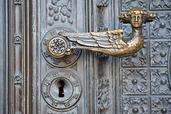 Antique Brass Angel Door Knocker on Ornate Metal Door