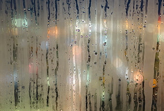 Raindrops on Window with Blurred City Lights Background