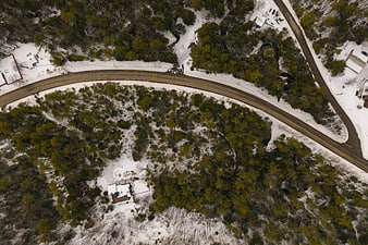 Aerial view of winding road through snowy winter forest