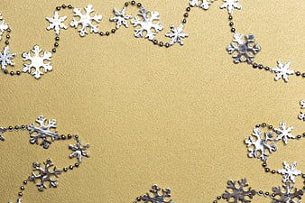 Silver snowflake garland on textured gold background