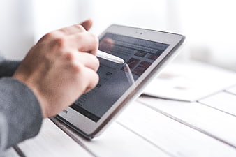 Hand using stylus on digital tablet screen