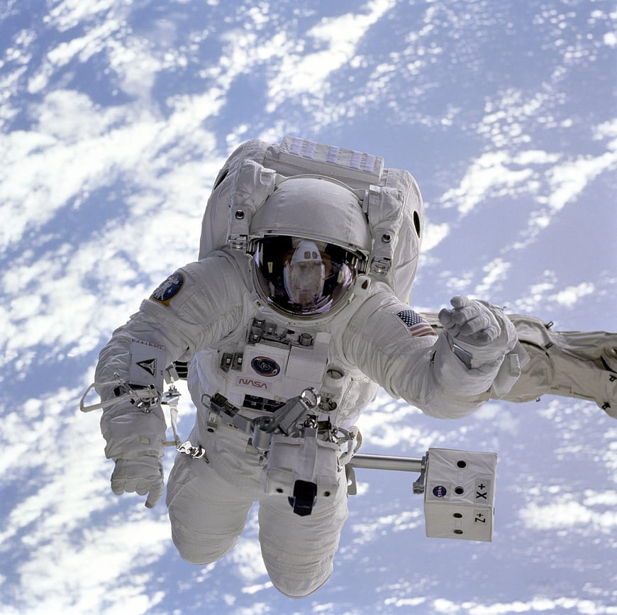 Astronaut in white spacesuit floating in space with Earth background