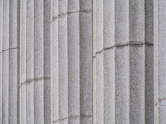 Close-up of gray stone fluted columns with classical architectural details