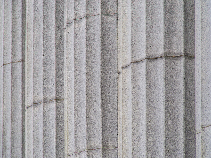 Close-up of gray stone fluted columns with classical architectural details