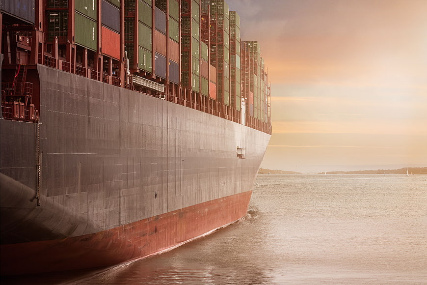 Massive Cargo Ship Sailing at Sunset